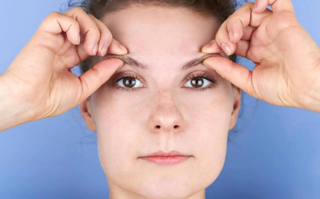 woman performing eyebrow lifting exercise