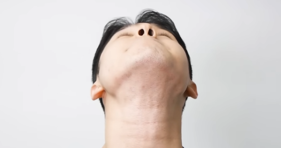 a man performing neck stretch exercise looking upwards